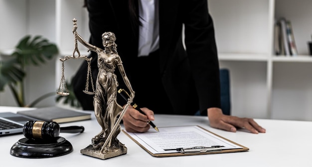 Foto mesa do advogado sobre a mesa está uma estátua de themis, que é a deusa da justiça e o martelo da justiça. os advogados costumam elogiá-la como um símbolo de justiça. conceito de lei e justiça.