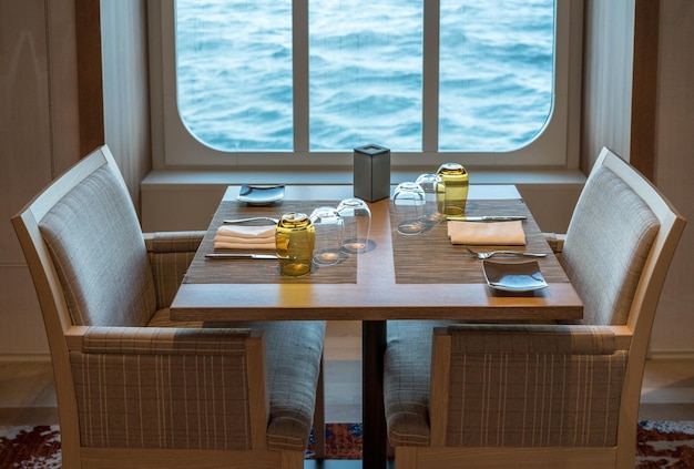 Mesa para dos en restaurante a bordo por ventana