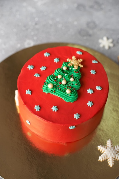 Foto mesa dulce de navidad decorada con guirnaldas de árboles de navidad verdes y juguetes pastel rojo para las vacaciones