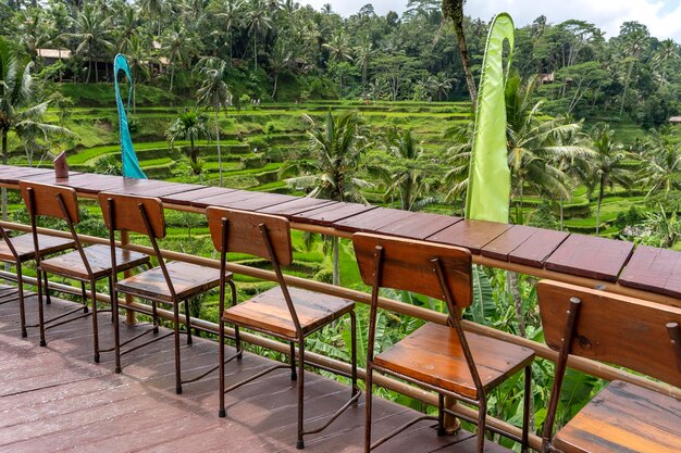 Mesa e cadeiras de madeira em café tropical vazio ao lado de terraços de arroz na ilha Bali Indonésia