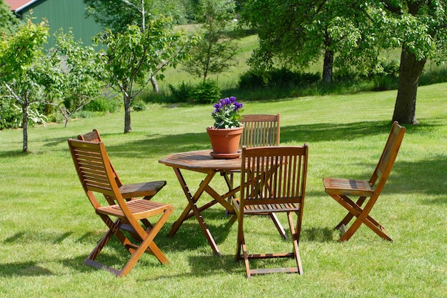 Mesa e cadeiras em um gramado no jardim