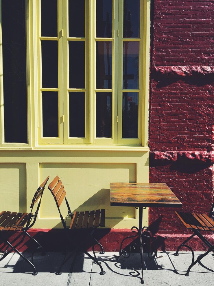 Foto mesa e cadeiras no café da calçada contra o edifício