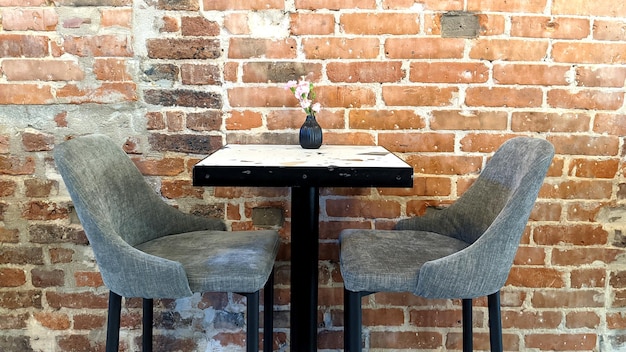 mesa e cadeiras no fundo de uma parede de tijolos