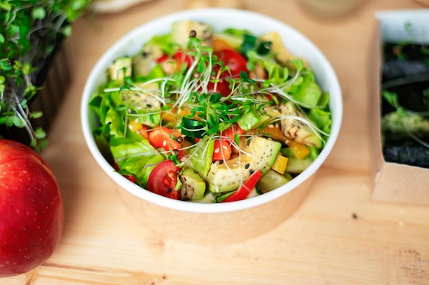 Mesa con ensalada saludable. Toma de primer plano, otros alimentos cerca en la mesa de madera