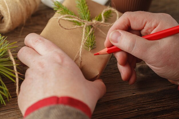 En la mesa envuelve regalos de Navidad. Hecho a mano