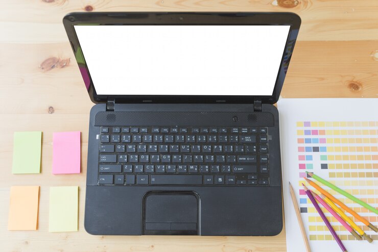 Foto mesa de escritorio de diseño gráfico con computadora, notas adhesivas y muestras de paleta de colores
