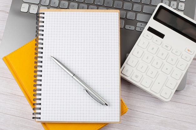 Mesa de escritorio de oficina con computadora portátil, cuadernos y calculadora, espacio de copia