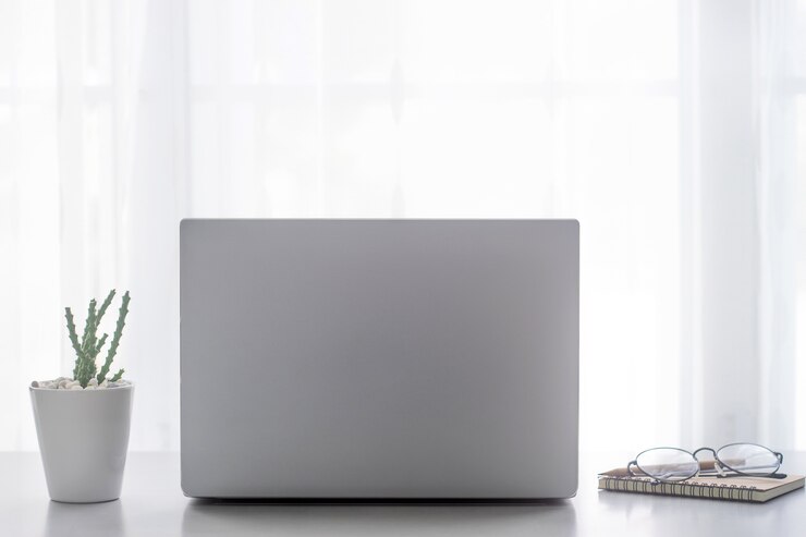 Mesa de escritorio de oficina con computadora portátil, suministros con espacio de copia en la oficina.
