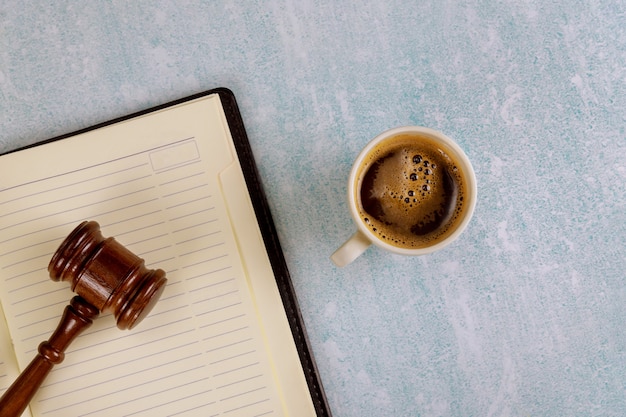 Mesa de escritorio de oficina de justicia legal con suministros, taza de café en un martillo de juez