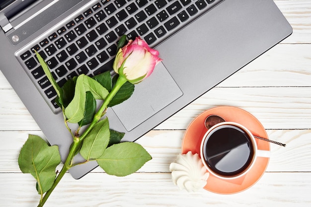 Mesa de escritorio de oficina con laptop rose y taza de café