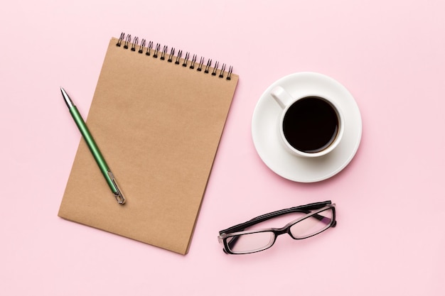 Mesa de escritorio de oficina moderna con cuaderno y otros suministros con taza de café Página de cuaderno en blanco para su diseño Vista superior plana