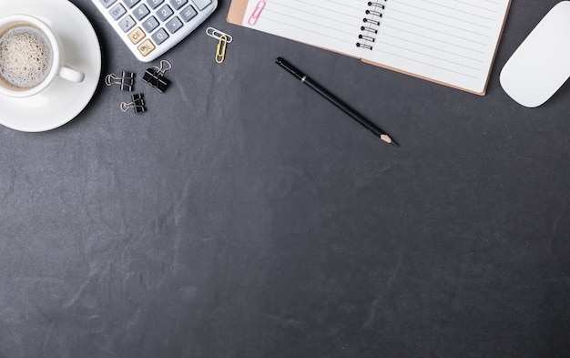 Mesa de escritorio de oficina negro con calculadora, nota de papel