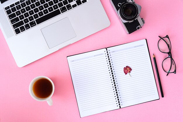 Mesa de escritorio de oficina con portátil, smartphone y taza de café portátil.