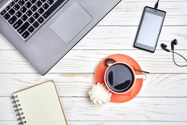 Mesa de escritorio de oficina con teléfono inteligente portátil y taza de café