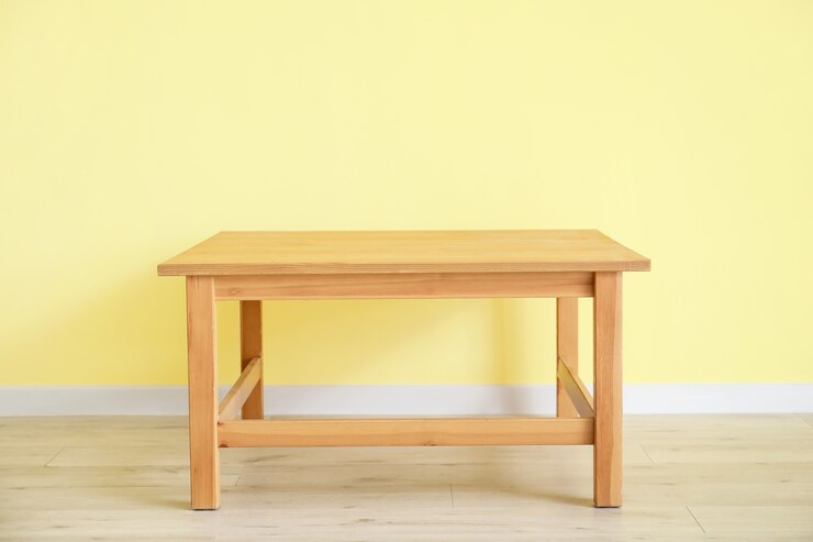 Foto mesa con estilo junto a la pared de color en la habitación