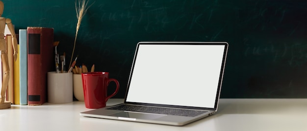 Mesa de estudio con libros de papelería para laptop