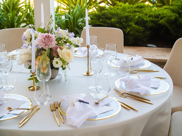 Mesa en el evento de recepción de bodas de lujo hermosas flores en la mesa y platos y vasos para servir un