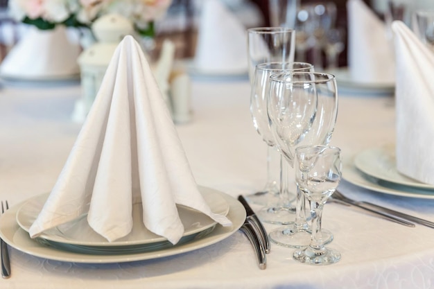 Mesa extravagante posta para jantar com óculos de guardanapo em restaurante de luxo fundo interior perna de casamento