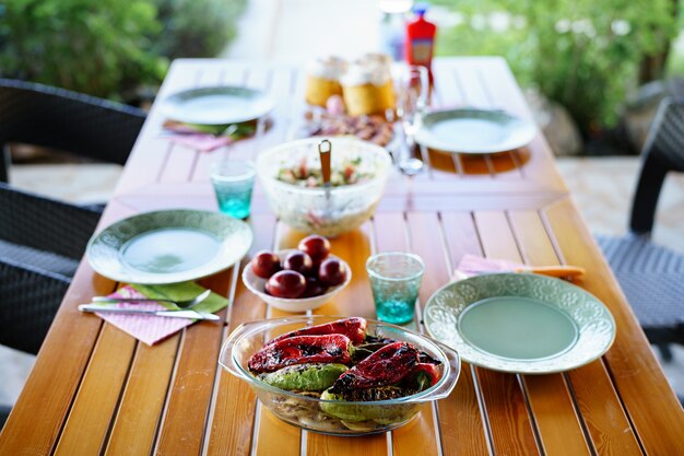 Mesa familiar con almuerzo en el jardín verduras asadas en un plato sobre la mesa