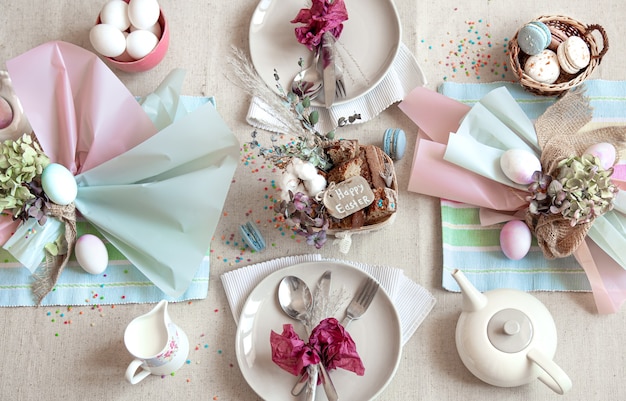 Mesa festiva decorada con postre de Pascua, té y huevos planos. Concepto de Pascua feliz.