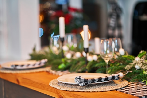 La mesa festiva de Navidad está decorada con ramas de un árbol de Navidad, velas y guirnaldas.