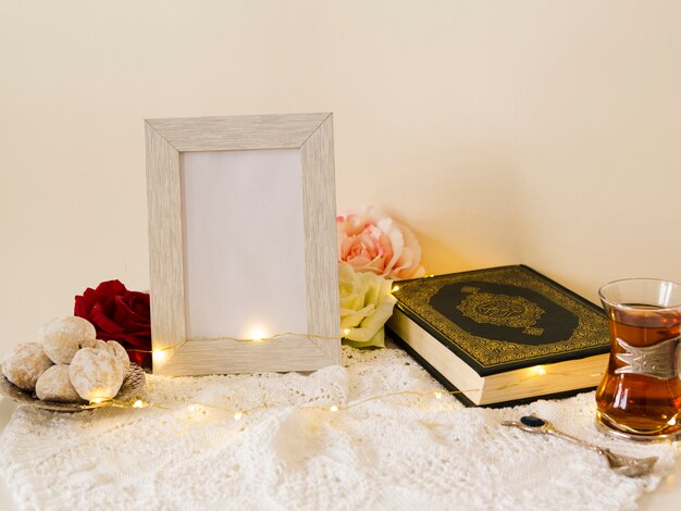 Foto mesa festiva con quran y marco de fotos.