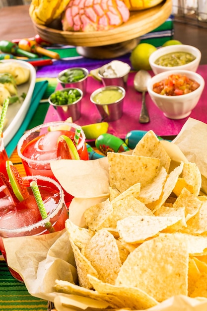 Mesa de fiesta con tamales, margaritas de fresa y pan dulche.