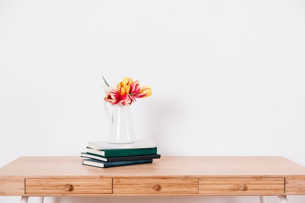 Foto mesa con flores y cuadernos