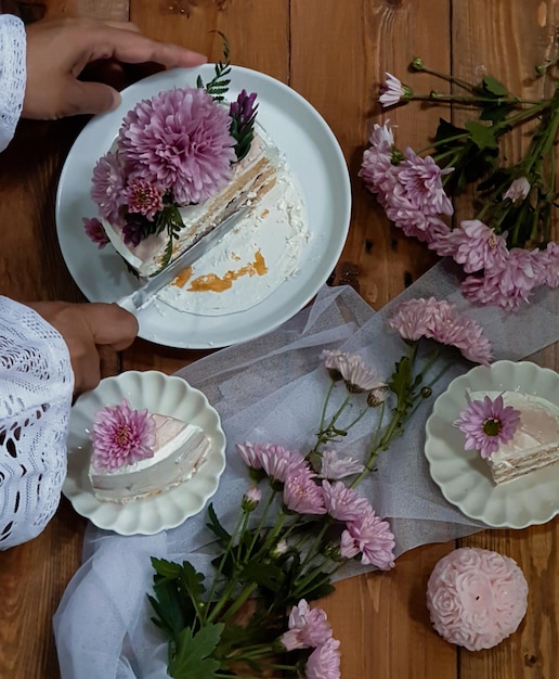 Una mesa con flores y un plato de pastel encima.