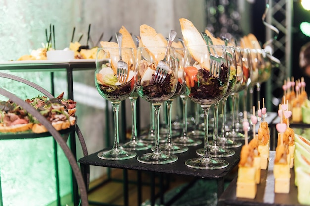 Mesa grande con bocadillos de diferentes tipos en una fiesta con iluminación disco creativa