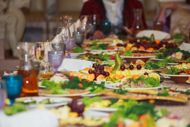 Mesa lindamente servida para banquete no restaurante Guardanapos brancos e taças de vinho azuis e verdes