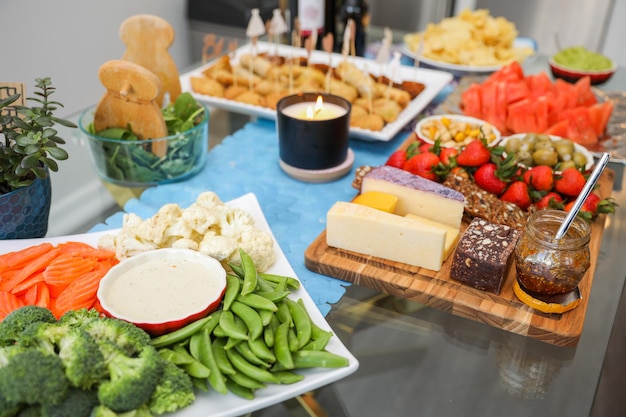 Una mesa llena de comida que incluye queso, verduras y carnes.