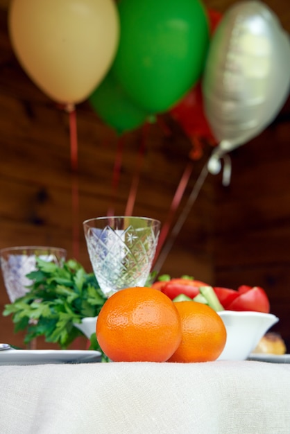 Mesa llena de comida vegetariana con globos de aire en madera