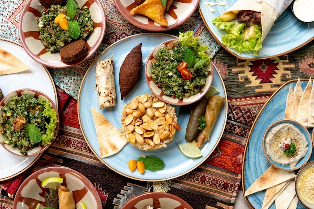 Foto una mesa llena de platos de comida, incluido un plato de comida y un plato de comida.