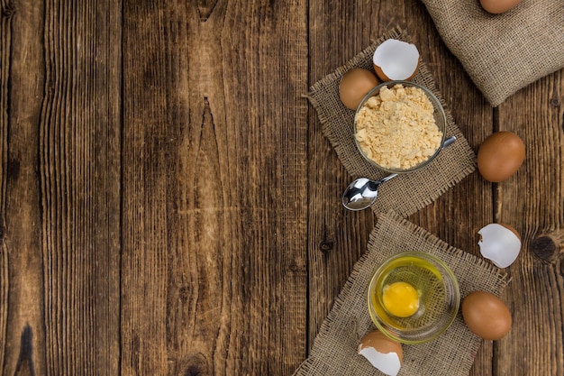 Mesa de madera antigua con huevos en polvo frescos primer plano enfoque selectivo