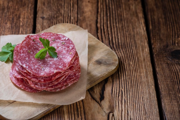 Mesa de madera antigua con salami en rodajas