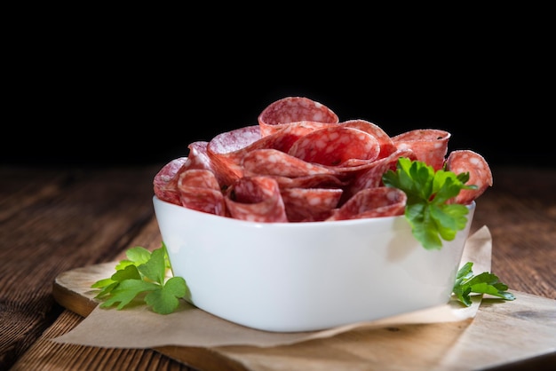 Mesa de madera antigua con salami en rodajas