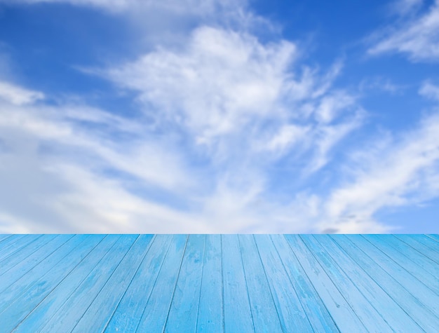 Mesa de madera azul con fondo de cielo borroso para cualquier diseño