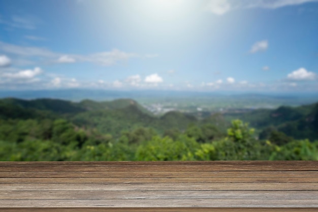 La mesa de madera y la belleza desdibujan el cielo y las montañas como fondoxA