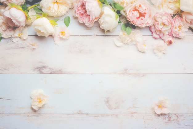Una mesa de madera blanca con flores rosas y blancas.