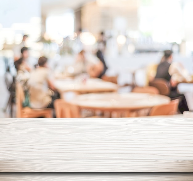 Mesa de madera blanca vacía y café borrosa con fondo de luz bokeh