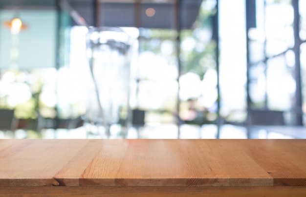 Mesa de madera con borrosa de cafetería para resumen