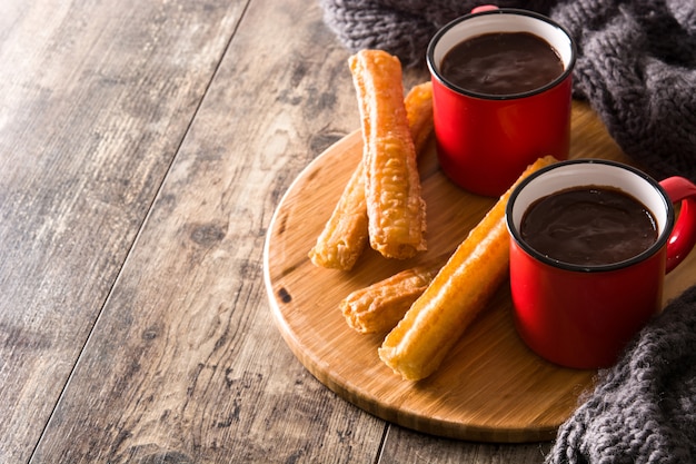 Mesa de madera de chocolate caliente con churros Copyspace