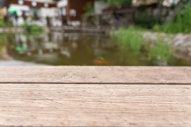 Mesa de madera contra el agua. Montaje con enfoque en el estante en primer plano y colocación del producto