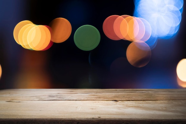 Mesa de madera contra luces iluminadas
