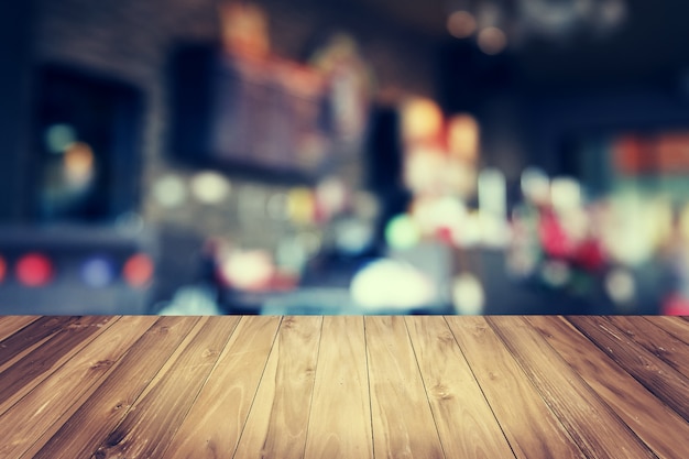 Mesa de madera y desenfoque de fondo de tienda de café