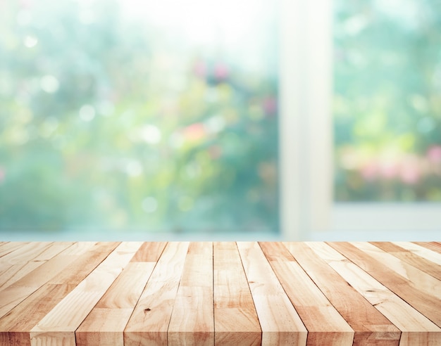 Mesa de madera en desenfoque de ventana con fondo de flores de jardín