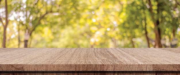 Mesa de madera para exhibición de productos alimenticios sobre desenfoque de fondo verde jardín