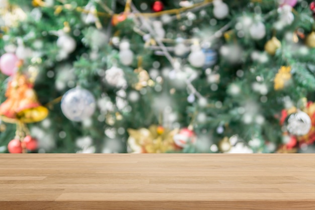 Mesa de madera en la falta de definición con bokeh Fondo de árbol de Navidad con filtro vintage - se puede utilizar para mostrar o montar sus productos