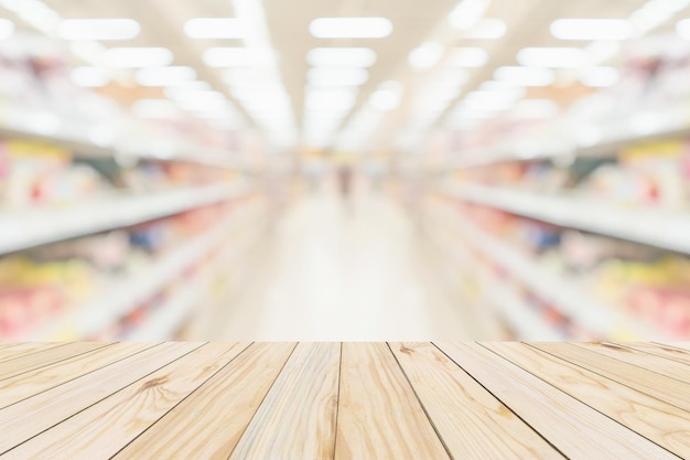 Foto mesa de madera con fondo borroso interior del pasillo de la tienda de comestibles del supermercado con luz bokeh para la exhibición del producto